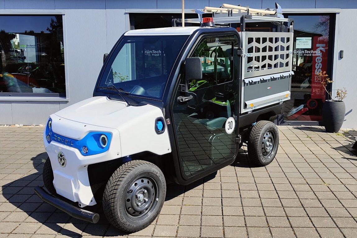 Weißes Goupil Elektrofahrzeug für kommunale Grünflächenpflege vor Werkstatt GrünTechnik Frank