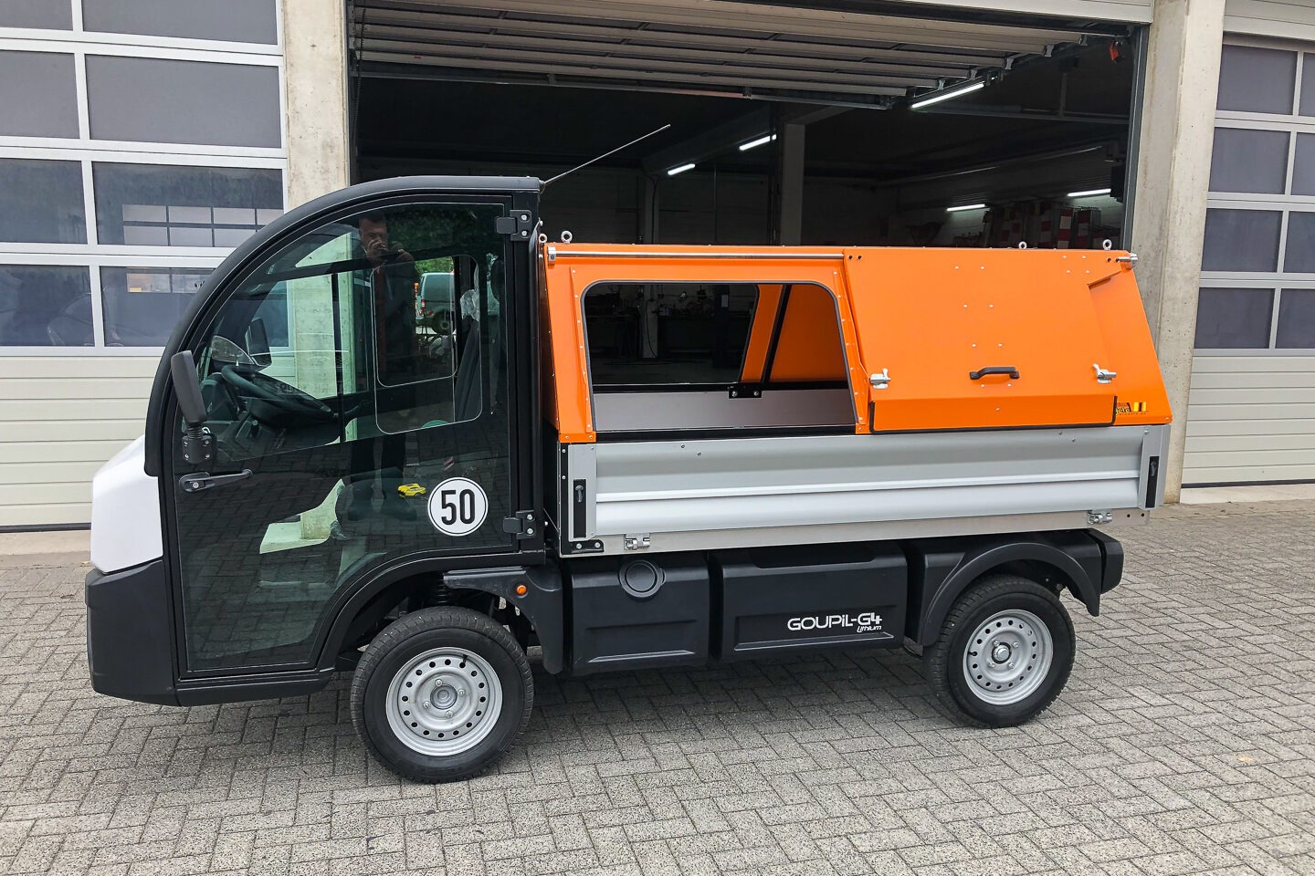 Schwarzes Goupil G2 Elektrofahrzeug mit oranger Ladefläche für Kommunalbetriebe – GrünTechnik Frank