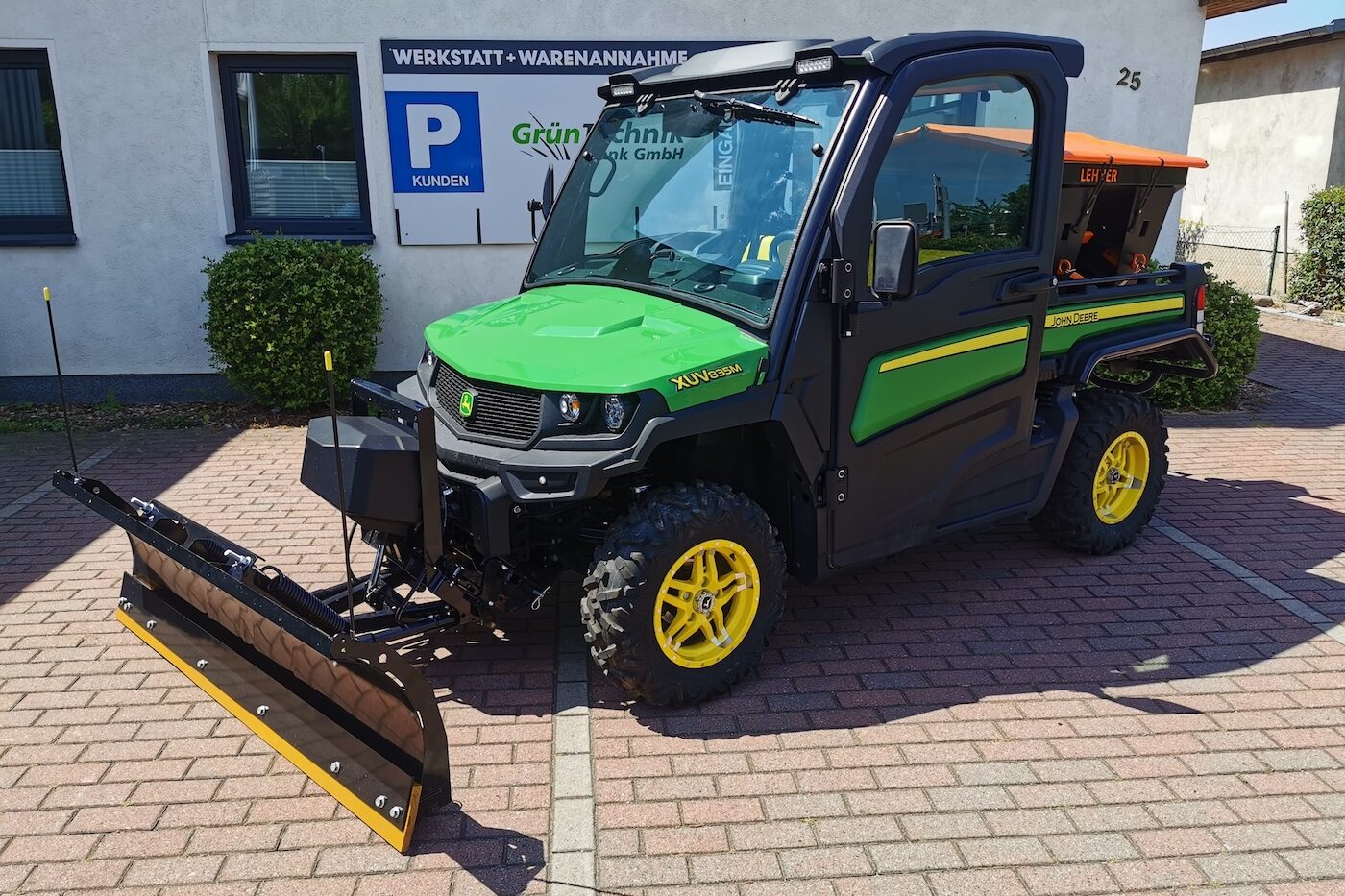 John Deere XUV Gator Geländefahrzeug mit Schneepflug vor GrünTechnik Frank Werkstatt