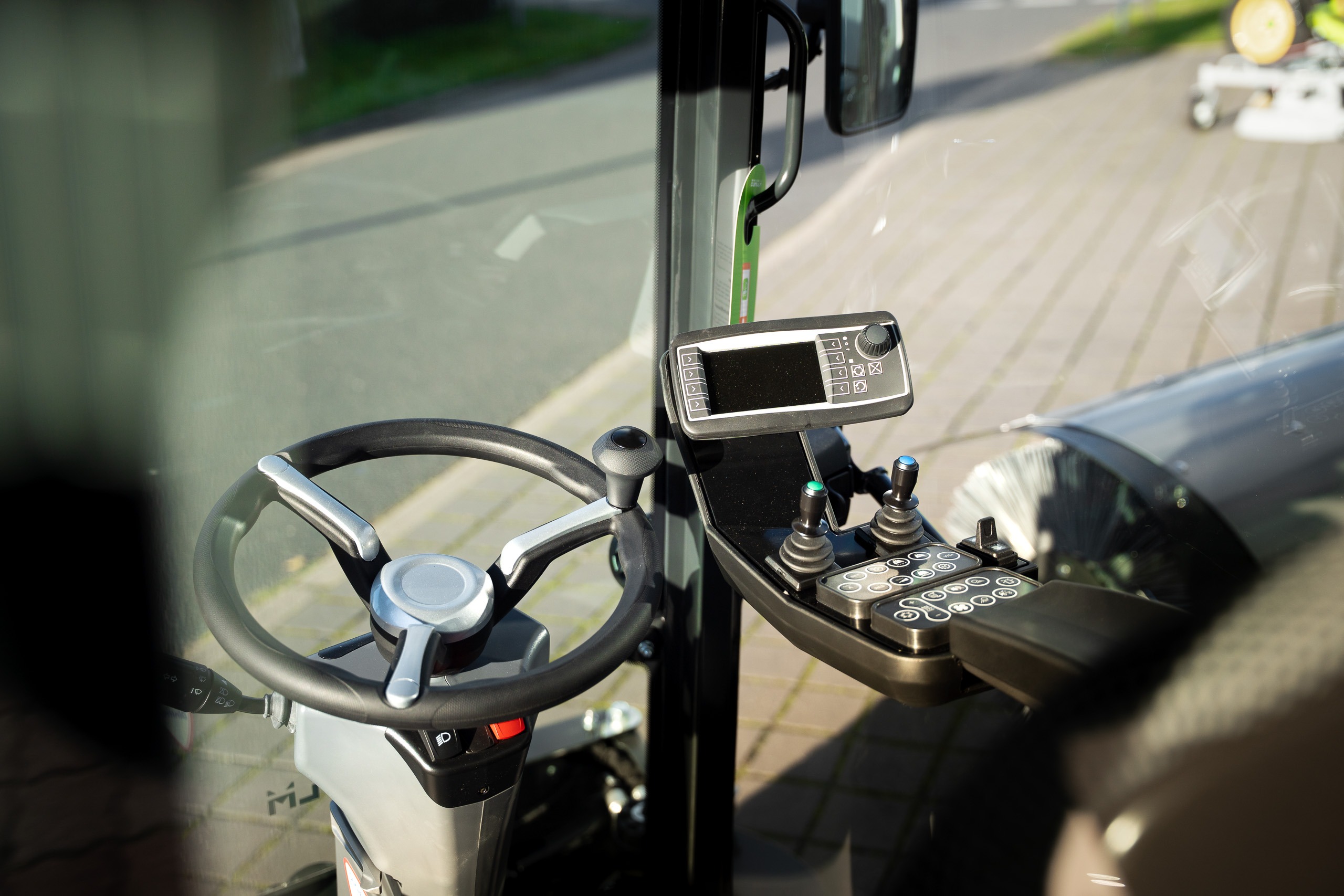Modernes Cockpit mit Display und Joystick-Bedienung in Kommunalfahrzeug – GrünTechnik Frank