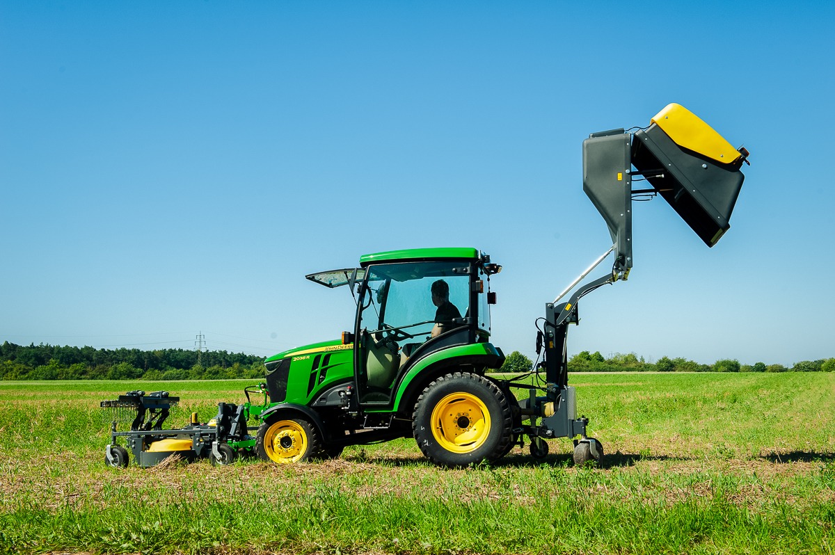 John Deere Multifunktionstraktor mit Frontmähwerk und Heckanbaugerät bei Grünflächenpflege